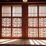 A traditional Korean Hanok wall made of Hwangto (red clay), showcasing its natural texture and breathable qualities, with soft sunlight filtering through a Changhoji (traditional paper) window, casting gentle shadows.